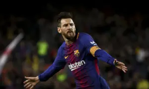 Piłkarz FC Barcelona, Lionel Messi, w niebiesko-bordowej koszulce z opaską kapitana na ramieniu, cieszy się z bramki.