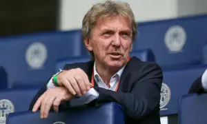 Zbigniew Boniek, żyje i ma się dobrze, siedzi na trybunach w garniturze, z charakterystycznymi wąsami.