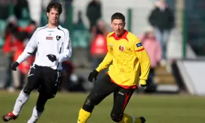 Młody Lewandowski w żółtej koszulce, jeszcze przed erą Legii Warszawa, walczy o piłkę na boisku.