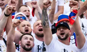 Tłum kibiców w barwach Górnika Zabrze, z uniesionymi pięściami i okrzykami radości.
