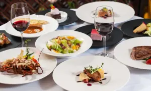 Elegancka kolacja w stylu dania francja: homar, steki, sałatka Cezar i desery, wszystko podane z czerwonym winem.