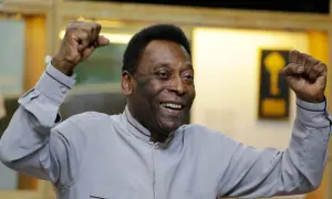 Uśmiechnięty Pelé z podniesionymi pięściami, symbol triumfu. Jego niesamowite pelé statystyki mówią same za siebie.