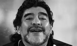Uśmiechnięty Diego Maradona, którego zdjęcie budzi pytania: czy Diego Maradona żyje? Ikona futbolu z charakterystyczną fryzurą i zarostem.