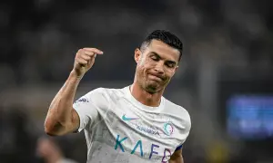 Cristiano Ronaldo z grymasem na twarzy, być może po kontuzji, unosi pięść.