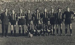 Drużyna Atalanty w historycznych strojach, gotowa do gry. W tle tłum kibiców. To zdjęcie przypomina o dawnych **atalanta transfery** i legendach klubu.