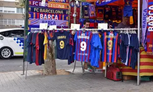 Stoisko z gadżetami FC Barcelona, w tym koszulkami z nazwiskiem Lewandowskiego. W tle widać radiowóz. Polacy w La Liga to już rzeczywistość!