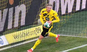 Erling Haaland w żółtej koszulce BVB z piłką, gotowy do gry. Jego daty dołączenia do klubu są kluczowe dla strategii zespołu.
