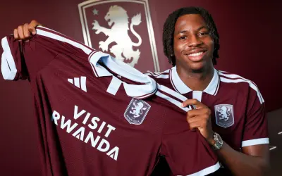 Uśmiechnięty piłkarz prezentuje nową koszulkę Aston Villa z napisem "Visit Rwanda". To ekscytujące wieści o aston villa transfery!