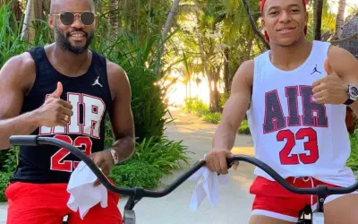 Brat Kyliana Mbappé, Ethan, w czarnej koszulce i czerwonych spodenkach, pozuje do zdjęcia z bratem, Kylianem, w białej koszulce i czerwonych spodenkach.