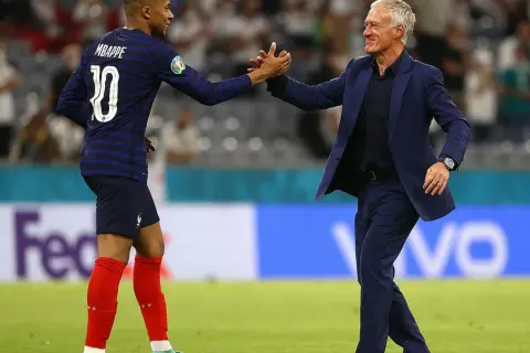 Mbappé i Deschamps, francuscy piłkarze, świętują sukces na boisku.