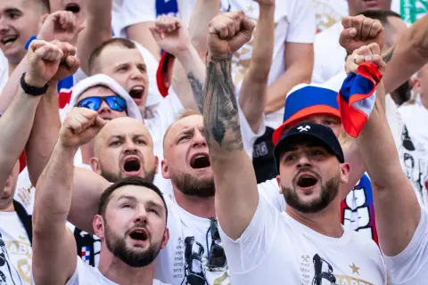 Tłum kibiców w barwach Górnika Zabrze, z uniesionymi pięściami i okrzykami radości.