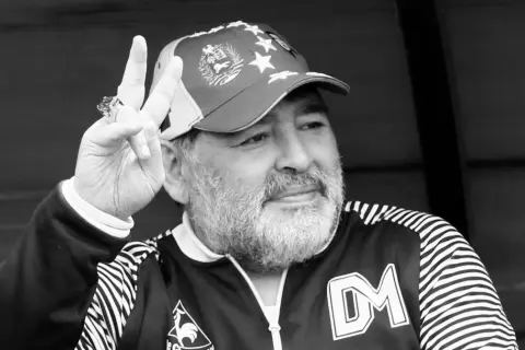 Diego Maradona, w czapce z gwiazdami, pokazuje znak pokoju. Ile lat ma Maradona? To pytanie zadają sobie fani.