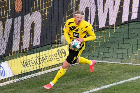 Erling Haaland w żółtej koszulce BVB z piłką, gotowy do gry. Jego daty dołączenia do klubu są kluczowe dla strategii zespołu.