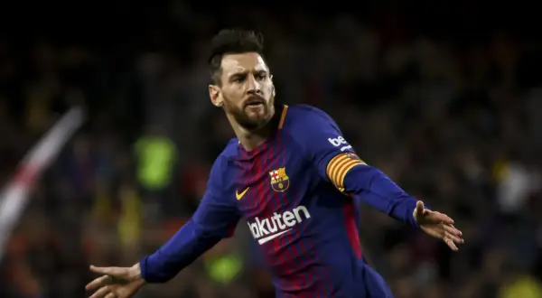 Piłkarz FC Barcelona, Lionel Messi, w niebiesko-bordowej koszulce z opaską kapitana na ramieniu, cieszy się z bramki.