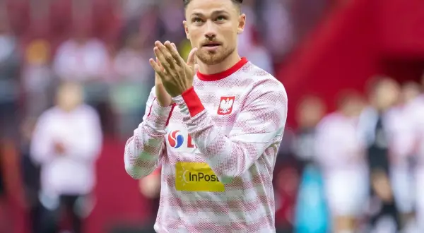 Piłkarz w koszulce z orłem i logo InPost, z dłońmi złożonymi do oklasków. To Mati Cash, gotowy do gry.