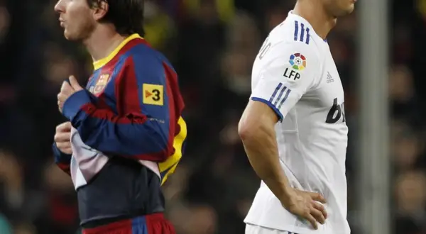 Dwóch najbardziej znanych piłkarzy na świecie, Messi w barwach Barcelony i Ronaldo w Realu Madryt, stoją obok siebie.
