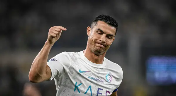 Cristiano Ronaldo z grymasem na twarzy, być może po kontuzji, unosi pięść.