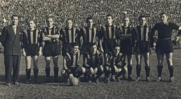 Drużyna Atalanty w historycznych strojach, gotowa do gry. W tle tłum kibiców. To zdjęcie przypomina o dawnych **atalanta transfery** i legendach klubu.