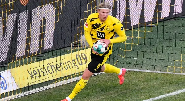 Erling Haaland w żółtej koszulce BVB z piłką, gotowy do gry. Jego daty dołączenia do klubu są kluczowe dla strategii zespołu.