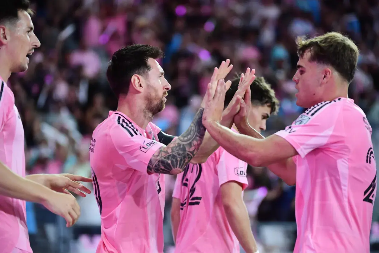 Piłkarze Inter Miami w różowych koszulkach świętują, jeden z nich to Lionel Messi, którego obecność cieszy każdego fana, jak i samego właściciela klubu.