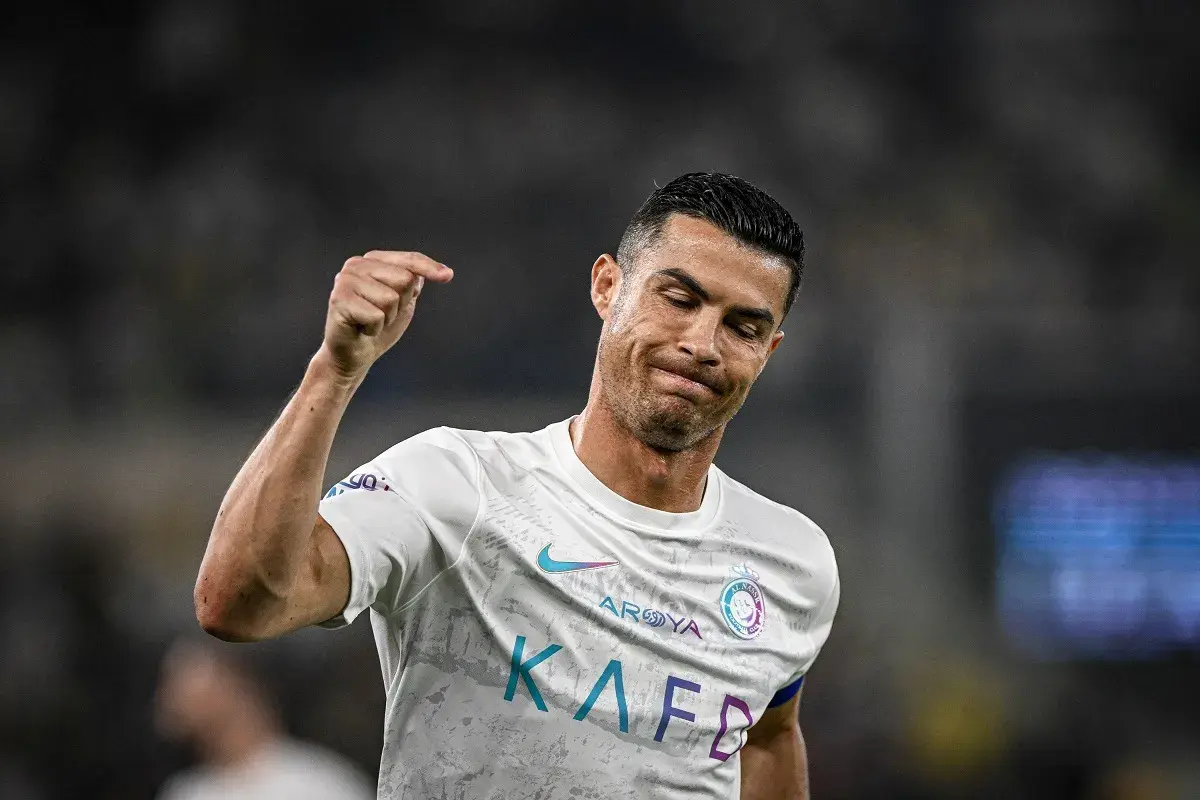 Cristiano Ronaldo z grymasem na twarzy, być może po kontuzji, unosi pięść.