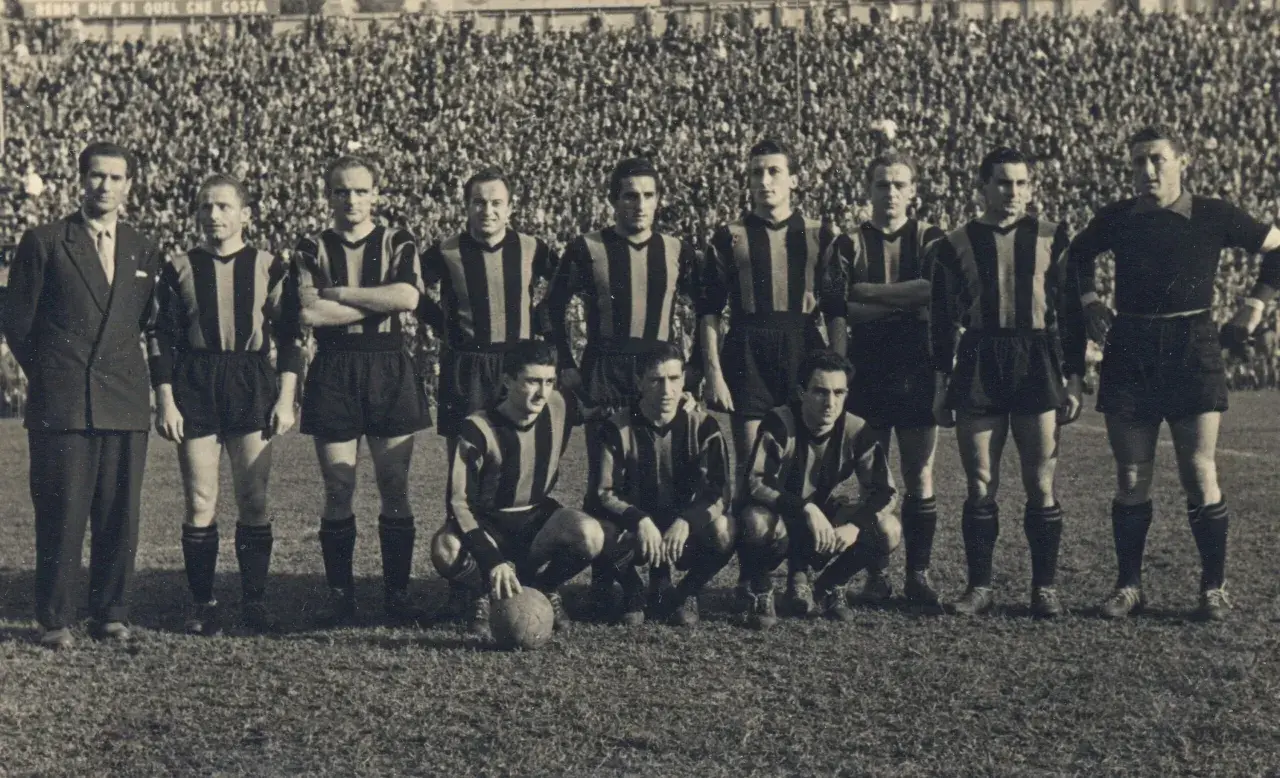 Drużyna Atalanty w historycznych strojach, gotowa do gry. W tle tłum kibiców. To zdjęcie przypomina o dawnych **atalanta transfery** i legendach klubu.