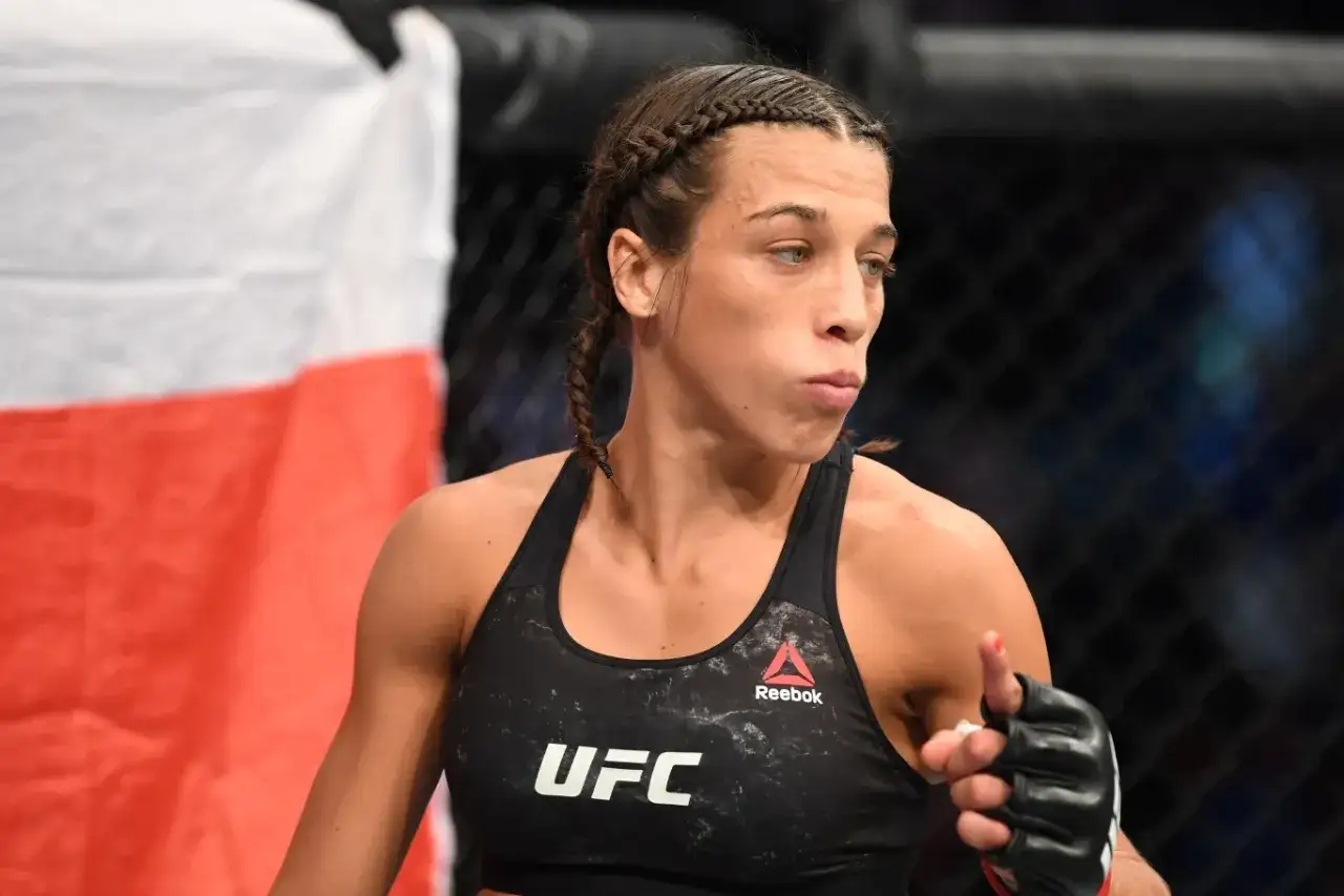 Joanna Jędrzejczyk, z warkoczami i w stroju UFC, gotowa do walki. Jej rekord mówi sam za siebie.