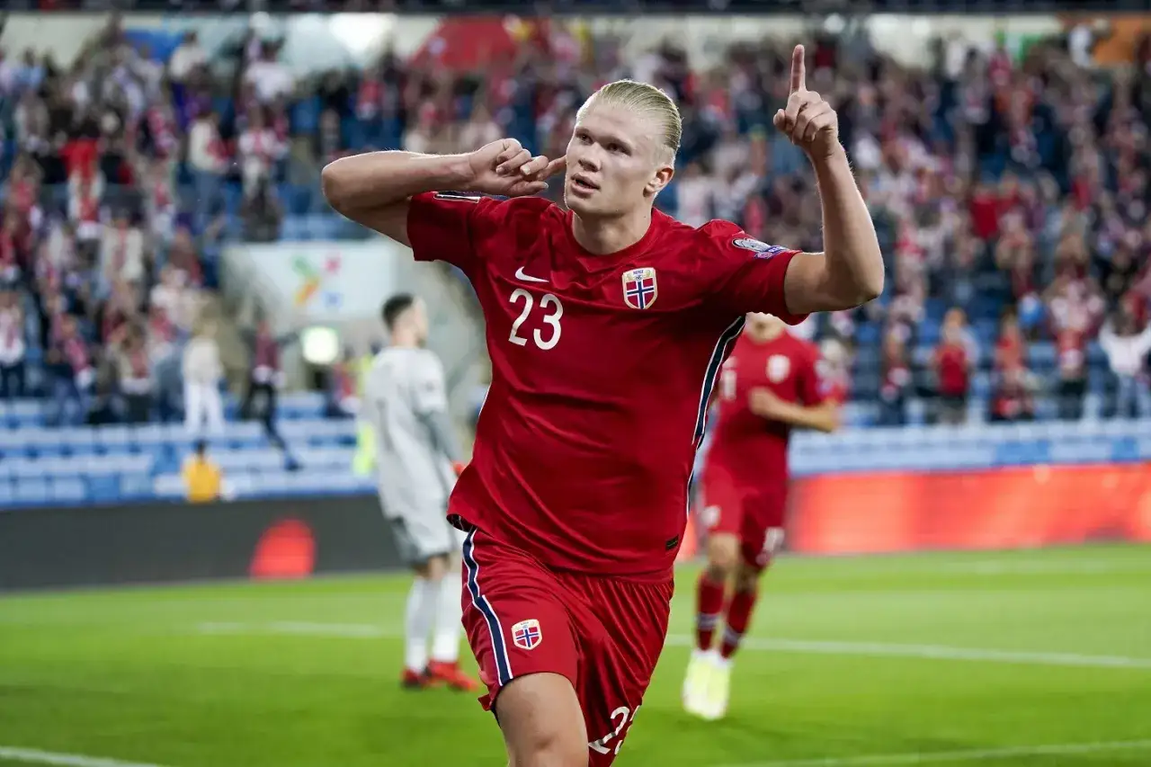 Piłkarz Erling Haaland w czerwonej koszulce z numerem 23, reprezentujący Norwegię, świętuje bramkę.