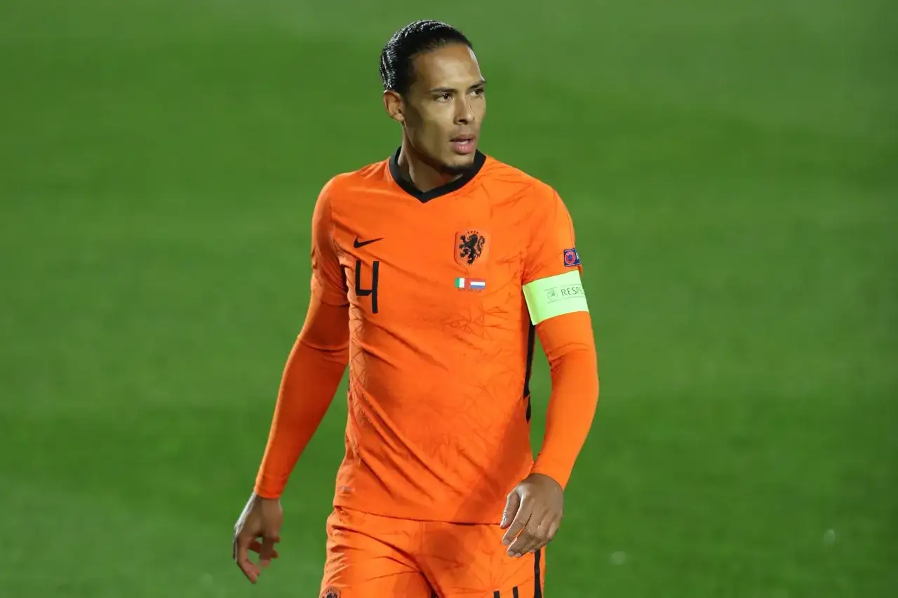 Virgil van Dijk w pomarańczowej koszulce reprezentacji Holandii, z numerem 4. Jego obecne drużyny to Liverpool FC i reprezentacja narodowa.