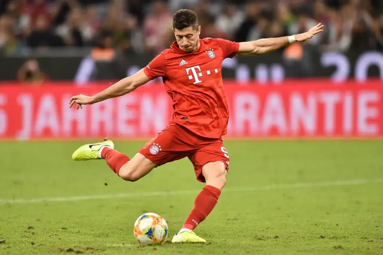 Robert Lewandowski wykonuje rzut karny, celując w bramkę.
