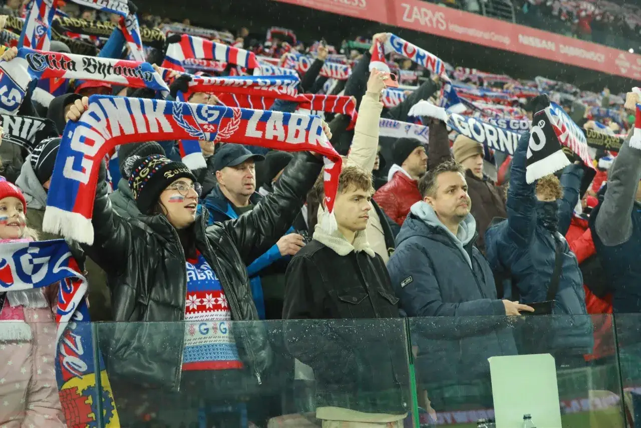 Kibice Górnika Zabrze z szalikami na meczu. Widać radość i doping na trybunach.