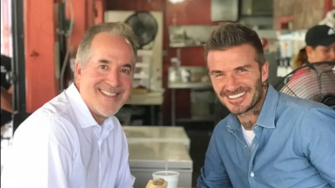 David Beckham, współwłaściciel Inter Miami, uśmiecha się do zdjęcia z kolegą w restauracji.