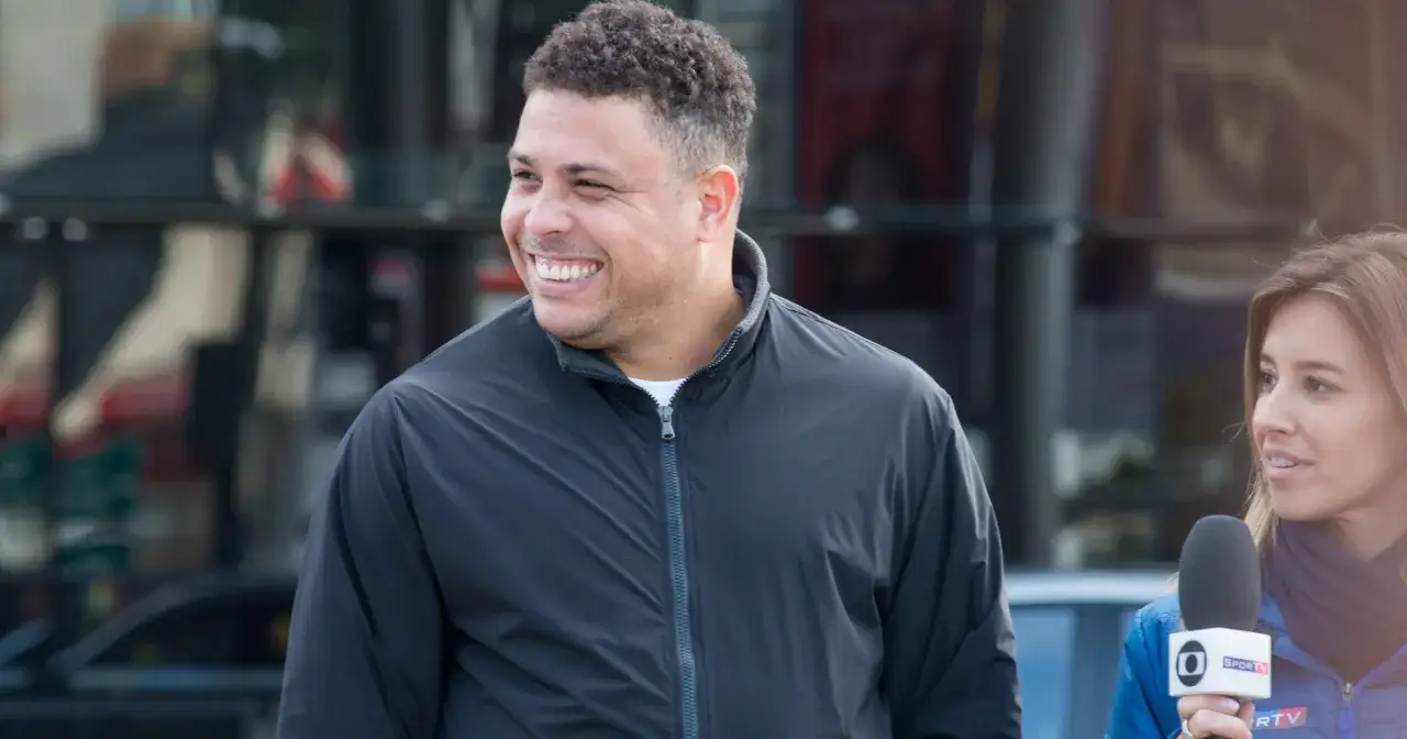 Uśmiechnięty Ronaldo Nazario, znany z imponującej kariery i niejednej zmiany wagi, rozmawia z dziennikarką.