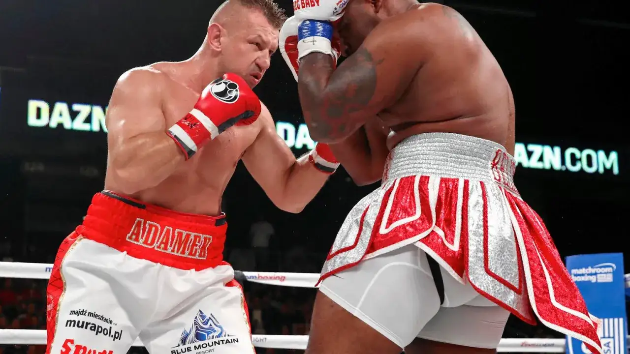 Tomasz Adamek w akcji, w czerwonych spodenkach z napisem 