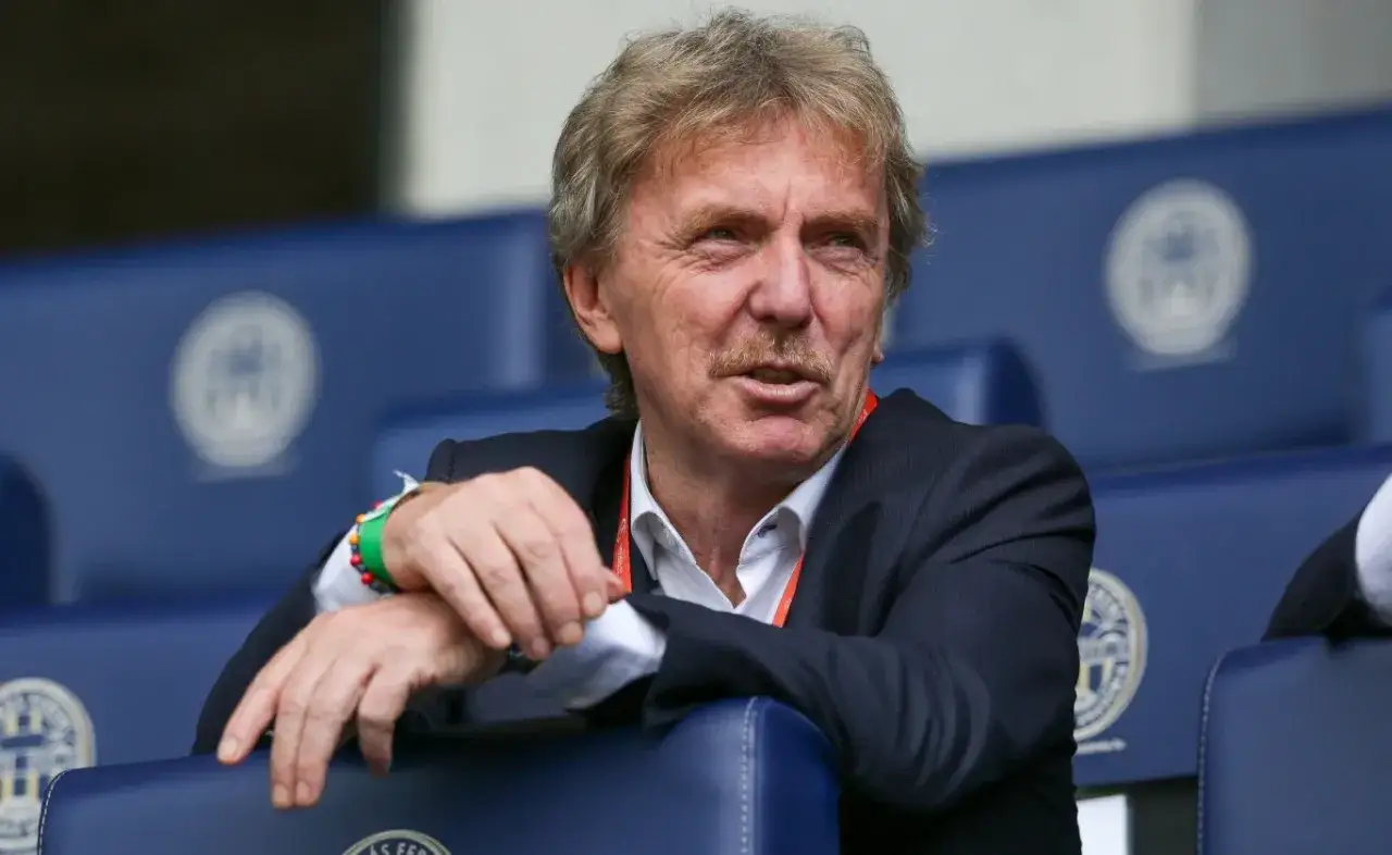 Zbigniew Boniek, żyje i ma się dobrze, siedzi na trybunach w garniturze, z charakterystycznym wąsem.