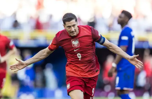 Robert Lewandowski cieszy się po strzelonym karnym. Piłkarz w czerwonej koszulce z numerem 9 świętuje zwycięstwo.